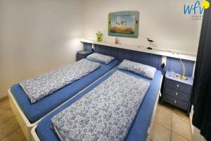 2 camas en una habitación con paredes azules en Luv und Lee Ferienwohnung Westerhever en Juist