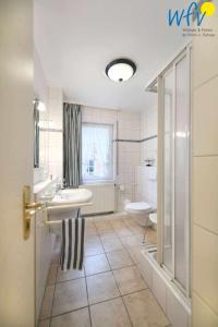 a bathroom with a sink and a toilet at Luv und Lee Ferienwohnung Westerhever in Juist +16 photos