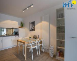 a kitchen and dining room with a table and chairs at Juist Zauber - Haus 3 Ferienwohnung Strandaster in Juist +3 photos