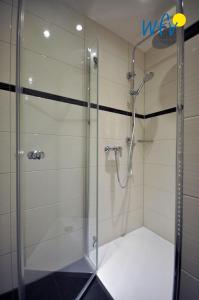 a shower with a glass door in a bathroom at Juist Zauber - Haus 3 Ferienwohnung Strandaster in Juist