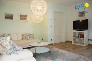 ein Wohnzimmer mit einem Sofa und einem Kronleuchter in der Unterkunft Ferienhaus Rademacher Ferienwohnung 1 in Binz