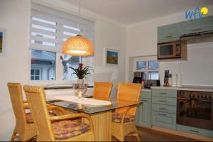 eine Küche mit einem Tisch und Stühlen sowie ein Esszimmer in der Unterkunft Ferienhaus Rademacher Ferienwohnung 1 in Binz