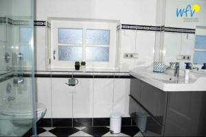 ein Bad mit einem Waschbecken, einem WC und einem Fenster in der Unterkunft Ferienhaus Rademacher Ferienwohnung 1 in Binz