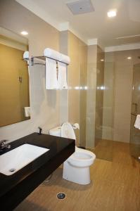 a bathroom with a toilet and a sink and a shower at Green Eden Hotel in Manado