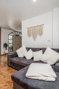 ein Wohnzimmer mit einer Couch mit Kissen darauf in der Unterkunft Nai Harn beach Villa 2 bdr in Rawai Beach + 11 Fotos