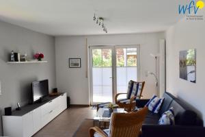 a living room with a couch and a tv at Juist Zauber - Haus 2 Ferienwohnung Jansen in Juist