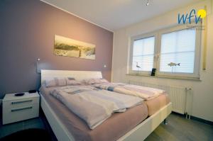 a large bed in a bedroom with a window at Juist Zauber - Haus 2 Ferienwohnung Jansen in Juist