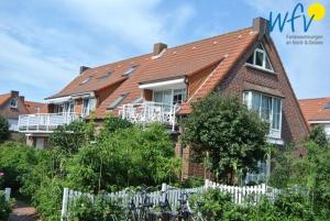a house with a white fence in front of it at Juist Zauber - Haus 2 Ferienwohnung Jansen in Juist