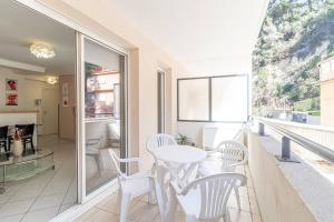 博索萊伊的住宿－One Bedroom Flat Near Monaco，一个带白色桌椅的阳台和一间房间
