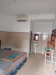 a bedroom with a bed and a sink in it at Cempaka 2 Homestay in Legian