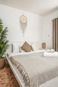 ein weißes Schlafzimmer mit einem großen Bett mit einer Decke in der Unterkunft Nai Harn beach Villa 2 bdr in Rawai Beach