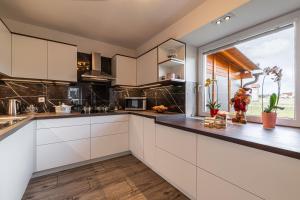 uma cozinha com armários brancos e uma grande janela em House Dijana With Pool - Happy Rentals em Nova Vas