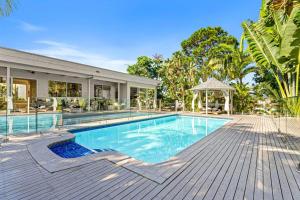 a swimming pool in front of a house at Waterfront Escape Sorrento, 5BD- Pool in Gold Coast