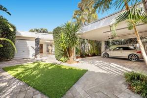a car parked in the driveway of a house at Waterfront Escape Sorrento, 5BD- Pool in Gold Coast