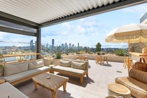 a patio with furniture and a view of the city at Sleek 1-Bed With Rooftop Pool & Amazing City Views in Brisbane
