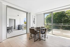 a dining room with a table and chairs and a large window at Sleek 1-Bed With Rooftop Pool & Amazing City Views in Brisbane