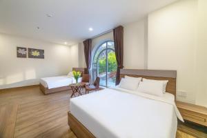 a hotel room with two beds and a table at TALA Dalat Hotel in Da Lat
