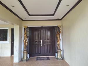 a front door with two statues on two pillars at La Dolce Vita Villa in Santa Rosa