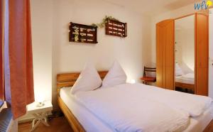 Schlafzimmer mit einem Bett mit weißer Bettwäsche und einem Spiegel in der Unterkunft Ferienpark Seedorf Fischerhaus - Ferienwohnung 8 in Sellin