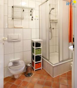 ein kleines Bad mit einem WC und einer Dusche in der Unterkunft Ferienpark Seedorf Fischerhaus - Ferienwohnung 8 in Sellin