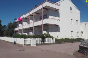 a large white building with a fence in front of it at Haus Oberlin Ferienwohnung 8 in Borkum