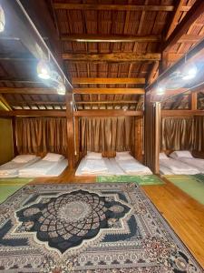 a room with two beds and a rug on the floor at Homestay Cao Nguyên Mộc Châu in Mộc Châu
