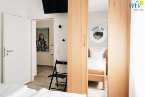 ein Schlafzimmer mit einem Spiegel und einem Bett sowie ein Zimmer in der Unterkunft Haus Oberlin Ferienwohnung 6 in Borkum