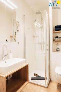 ein Badezimmer mit Waschbecken und Dusche in der Unterkunft Haus Oberlin Ferienwohnung 6 in Borkum + 14 Fotos
