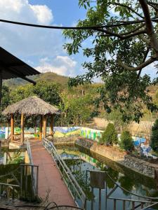 a walkway next to a pond at a zoo at Homestay Cao Nguyên Mộc Châu in Mộc Châu