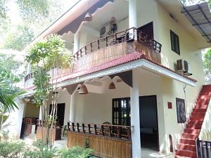 a house with a balcony and a staircase at Agasthya in Varkala