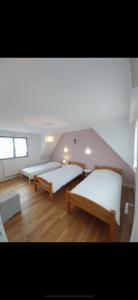 - 2 lits dans une chambre dotée de parquet dans l'établissement Maison de charme vue mer 180 rénovée Accès plage, à Riantec