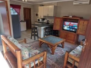 a living room with a table and chairs and a kitchen at Wilreco self carting 2 bedroom flat. in Bloemfontein