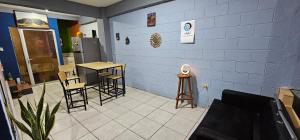 ein Zimmer mit Stühlen, Tischen und einer blauen Wand in der Unterkunft La Casa de Diego in Santa Ana