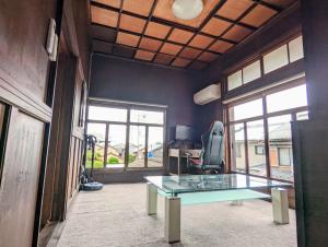 an office with a glass table and a chair at Kanchantei The Main House in Minamicho