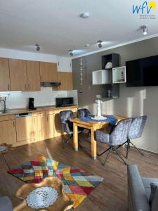 a living room with a table and a kitchen at Holiday Residenz II Ferienwohnung Möwennest in Borkum