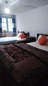 two beds sitting in a room with at Country cottage in Nuwara Eliya