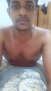 a man without a shirt laying on a bed at Country cottage in Nuwara Eliya