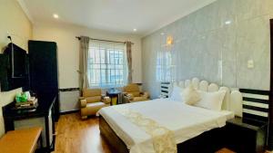 a bedroom with a large bed and a living room at Linh Phuong 2 Hotel in Can Tho