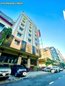 芹苴的住宿－靈芳2酒店，一座高大的建筑,前面有汽车停放