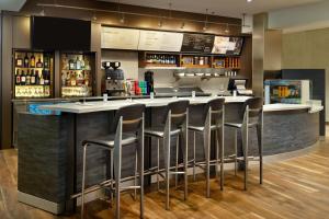 a bar with a row of stools in a restaurant at Courtyard by Marriott New Orleans Metairie in Metairie
