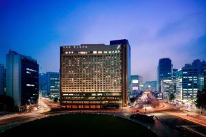 a large building in the middle of a city at night at THE PLAZA Seoul, Autograph Collection in Seoul