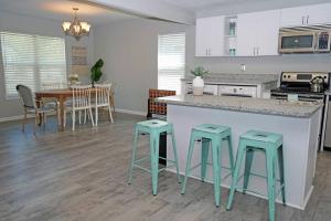 a kitchen with a counter and a table with stools at The Blue Pearl 6min to Downtown -Short Beach Drive in Pensacola