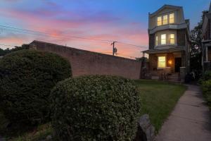 a house with a clock on the side of it at Modern Renovated & Comfy East Germantown Adobe in Philadelphia