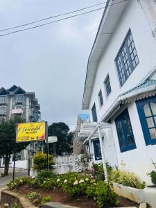 a white building with a sign in front of it at Serendib Hotel in Nuwara Eliya