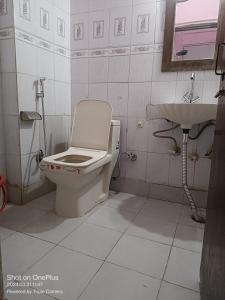 y baño con aseo y lavamanos. en Mother Palace, en Nueva Delhi
