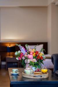 a table with a vase of flowers on it at Seventeen Rooms in Tʼelavi