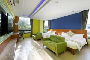 a hotel room with two beds and a green chair at Oceanic Pearl Resort in Xiaoliuqiu