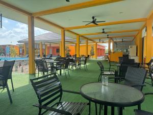 un patio al aire libre con mesas y sillas y una piscina en Capital O 90949 Pelangi Beach Resort Mersing en Mersing