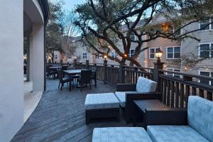 um pátio com mesas, cadeiras e uma árvore em Courtyard by Marriott Austin The Domain Area em Austin