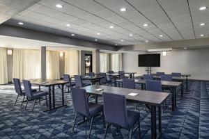a conference room with tables and chairs and a screen at Courtyard by Marriott Austin The Domain Area in Austin